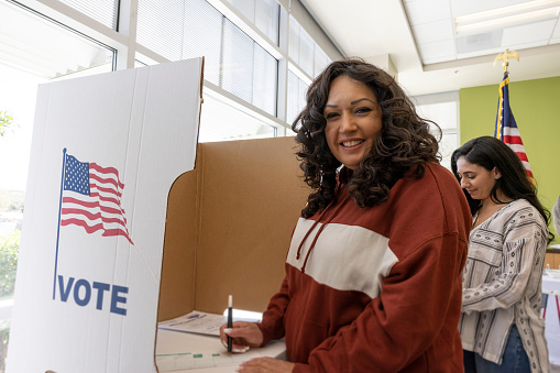 A Native American woman voting at a local community center.