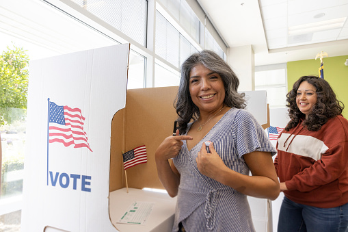 A Hispanic woman voting at a local community center.