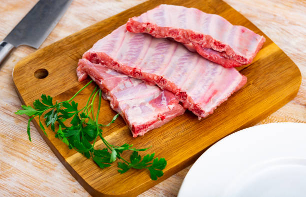 istock Uncooked pork ribs rack ready for cooking on cutting board 1432432456