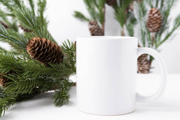 istock White ceramic cup on a wooden table with green spruce branches. Mockup with copy space. Mug with hot drink front view. 1432432521