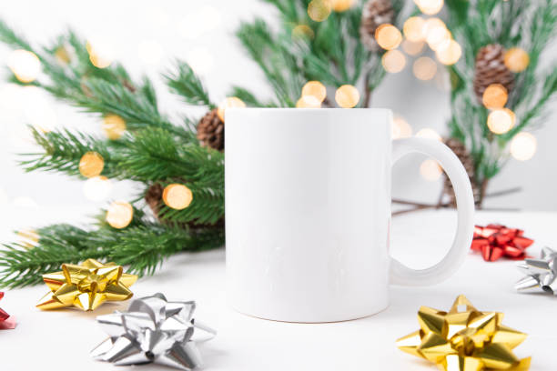 istock White ceramic cup mockup with copy space for text and logo and christmas tree in the background. 1432432531