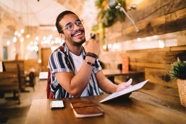 istock Positive man with tablet smartphone and notebook in cafe 1432433741