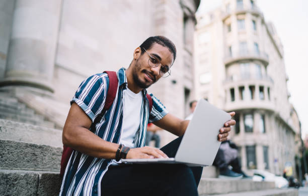 istock Concentrated man with netbook sitting on stairs 1432433770