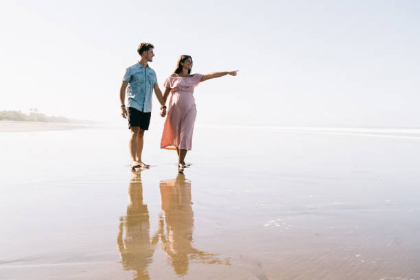 istock Young couple standing on water on sunny day 1432433847