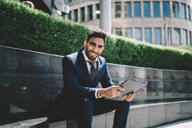 istock Smiling man with folder sitting in city 1432434098
