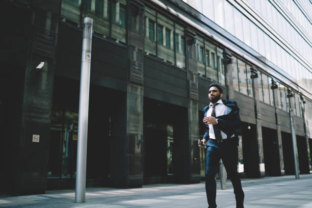 istock Ethnic businessman walking in downtown at daytime 1432434126