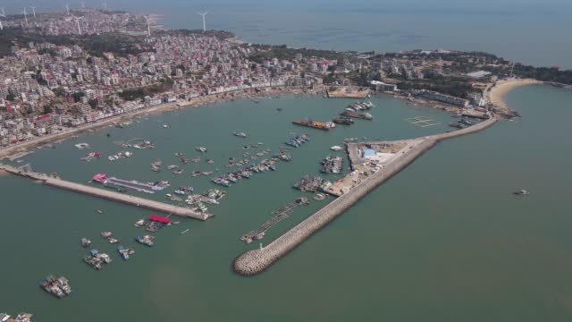 Aerial view video of the dyke of the fishing port and the docked ships
