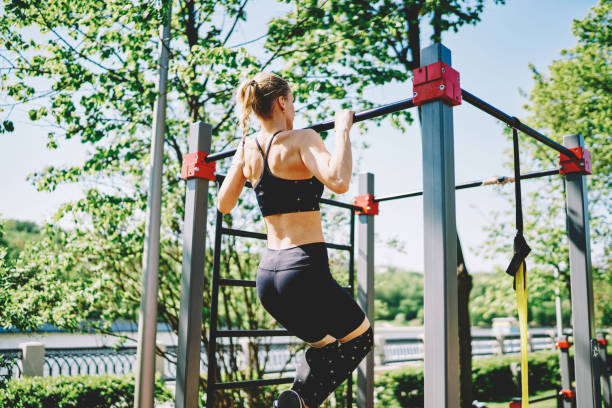 istock Sporty lady doing pull up exercises on bar in park 1432435061