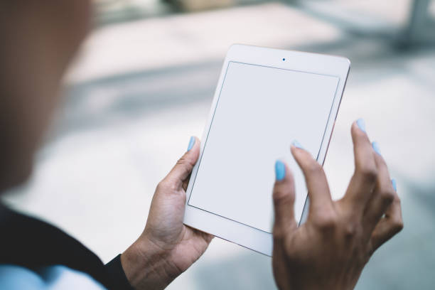 istock Unrecognizable woman surfing tablet in street 1432437785