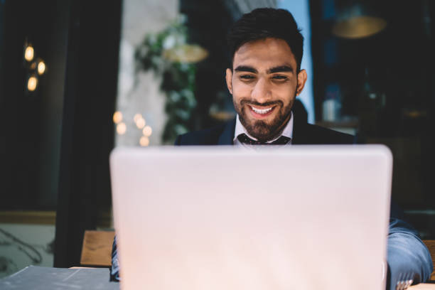 istock Cheerful businessman browsing laptop in cafeteria 1432437789