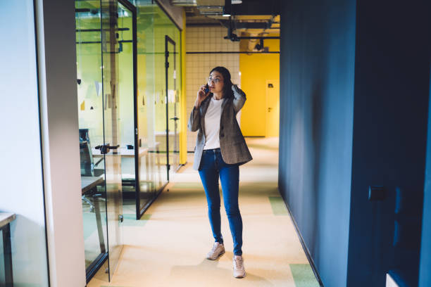 istock Beautiful woman standing in hall during phone conversation 1432437969