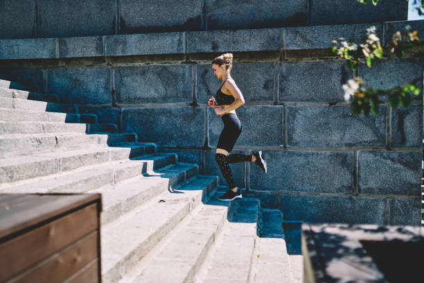 istock Young sportswoman in gym suit practicing run upstairs at outdoors stadium 1432438229