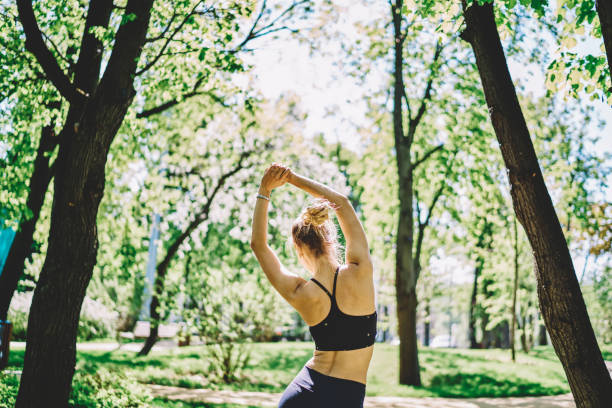 istock Slim sportive lady warming arms up in park 1432438260