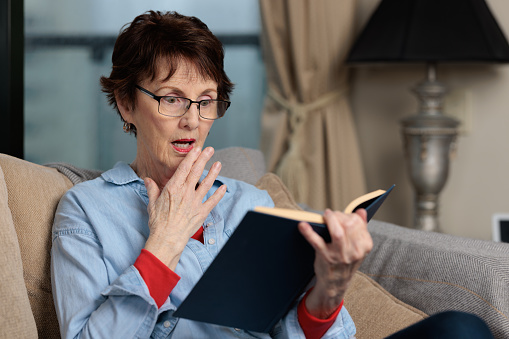 Senior woman gets a shock from what she has just read.