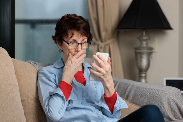 istock Woman looking at her phone with a shocked expression indoors 1432439390