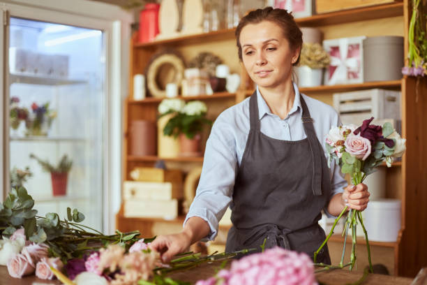Florist busy making fresh pink bouquet stock photo