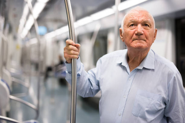 istock Old man standing in subway car 1432442956