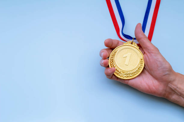 hand holding gold medal stock photo