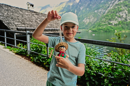 Boy play with wooden toy doll in Hallstatt, Austria.