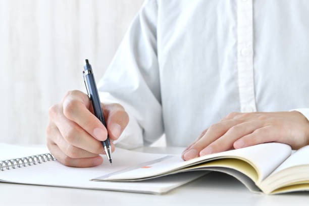 Human's hands studying hard with notebook and textbook Human's hands studying hard with notebook and textbook adults only stock pictures, royalty-free photos & images