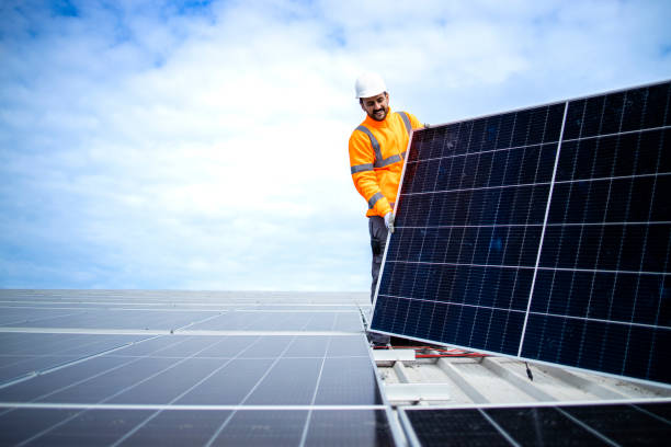 istock Professional worker carrying solar panel module and installing power plant on the roof. 1432455914