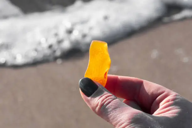 Photo of Beautiful big piece of yellow amber in the hand of a girl