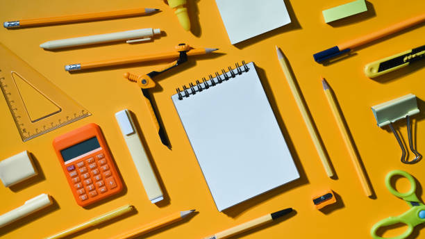 istock Blank notepad and various school supplies on yellow background. Flat lay, Top view. 1432461971