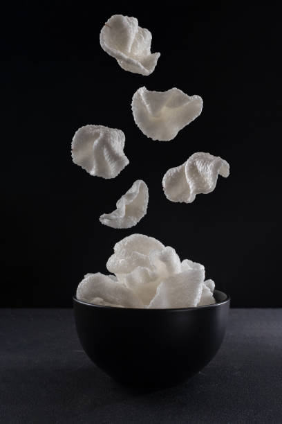 Rice Krispies on a black background. Levitation, chips falling on the plate