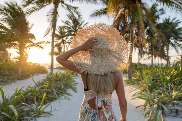 istock Young woman walks towards tropical beach at sunset 1432462290