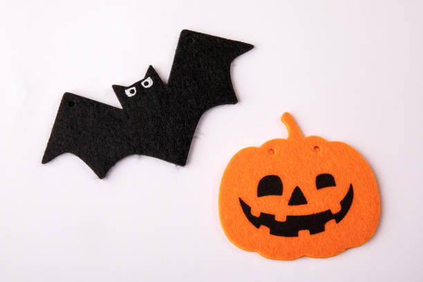 istock Pumpkin with a smile and a bat on a white background. Halloween decorations 1432463875