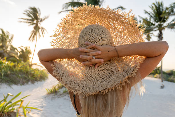 30's woman walks on a beautiful wild beach with palm trees in Mexico.