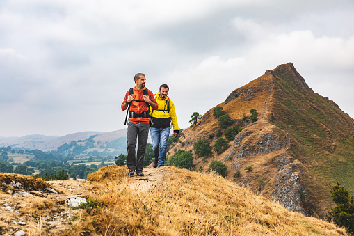 Two men hiking on top of a mountain ridge