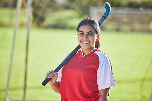 Happy female hockey coach portrait, women's team sport player with natural field background outdoors alone. Confident leader training for competition, motivation fitness and collaboration exercise.