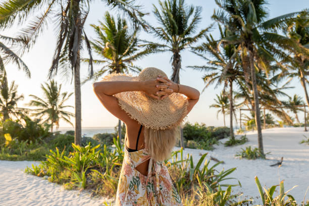 istock Young woman walks towards tropical beach at sunset 1432464516