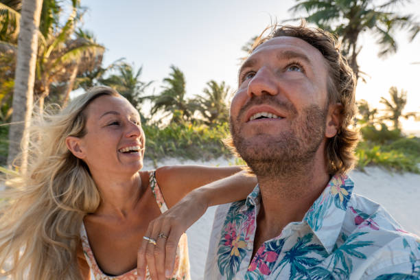 istock Couple relaxing on tropical beach at sunset 1432464520