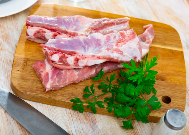 istock Raw pork ribs ready for cooking on cutting wooden board 1432465032