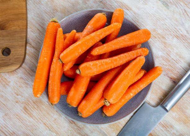 istock Heap of raw carrots on wooden table 1432465039