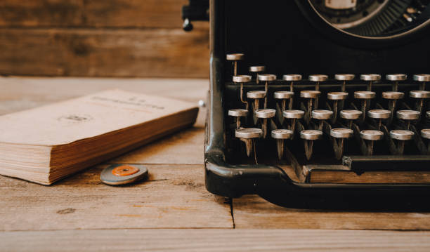 una máquina de escribir vintage con una goma y un libro viejo. - typewriter typing machine old fotografías e imágenes de stock