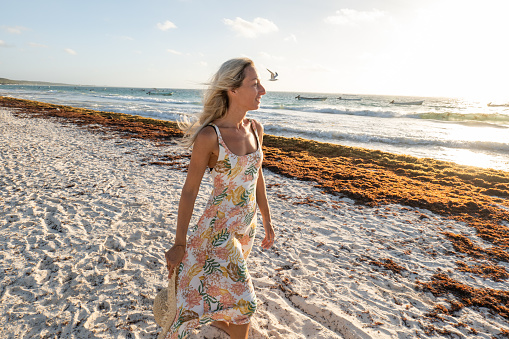 30's woman walks on a beautiful wild beach in the morning, mindfulness.