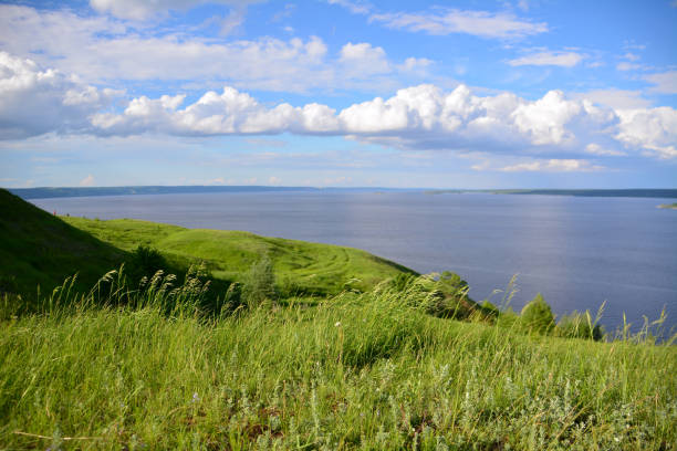 край холма с рекой и вечернее небо с белыми �облаками - hiking coastline waters edge sunny стоковые фото и изображения