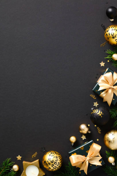 istock Christmas vertical banner. Luxury Christmas ornaments, baubles, gift boxes, fir branches on black background. Flat lay, top view, copy space. Xmas poster template. 1432468005