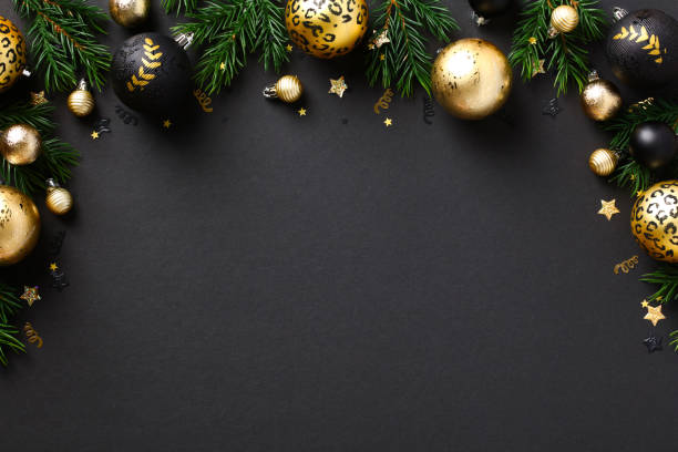 Merry Christmas greeting card template, frame, New Year banner design. Luxury gold baubles and fir branches on black background. Winter holidays composition. Flat lay, top view. stock photo