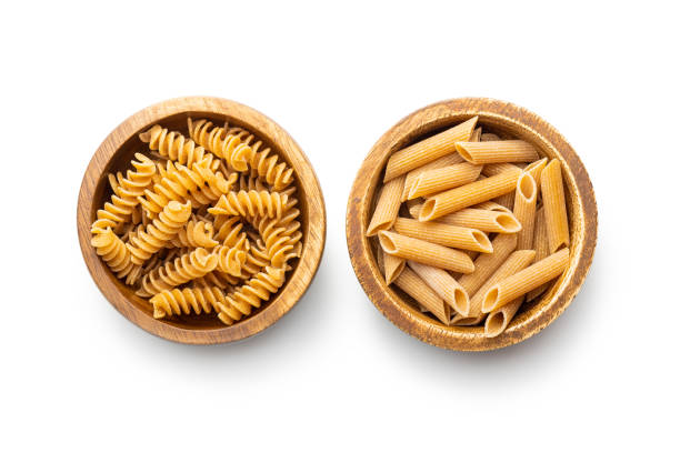 istock Uncooked whole grain pasta isolated on white background. Raw pasta in bowl. 1432469785