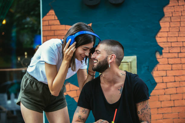 happy loving couple with headphones sharing music in cafe - headphones women tattoo music imagens e fotografias de stock