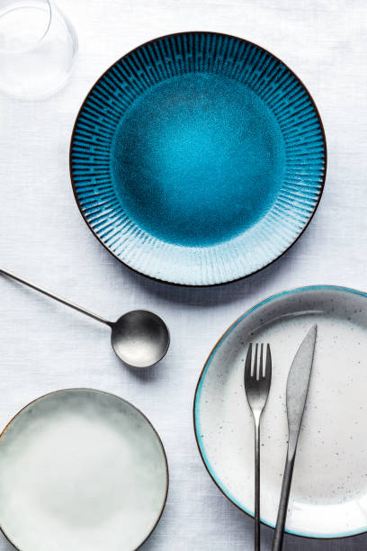 istock Modern tableware set with a vibrant blue plate, cutlery, and a glass 1432472479