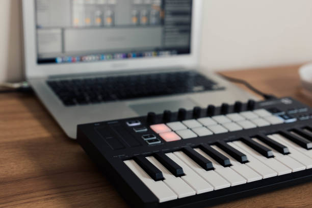 istock Midi Keyboard musician playing midi keyboard for arranging music on laptop computer Music production technology concept 1432473573