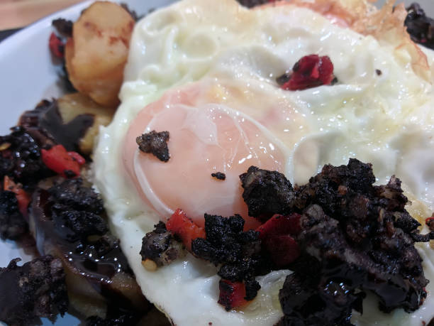 istock Huevos Rotos Recipe: Spanish Broken Eggs with potato and blood sausage in a plate. 1432477272