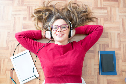 Happy young woman smiling and listening to podcast