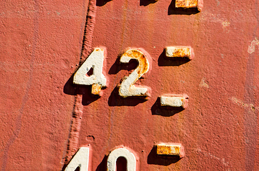 Close-up of the draught marks on a weathered ship's hull, focussing on the number 42