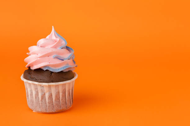 istock Cupcake with birthday candles on orange background 1432482623